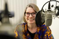 Viveka Kjellmer sitter framför micken i poddstudio
